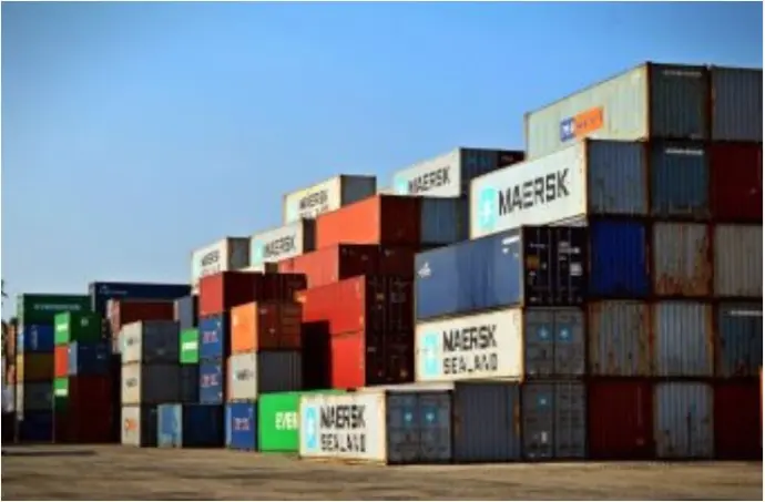 A stack of multi-colored shipping containers (Maersk and MSC) at a logistics terminal.