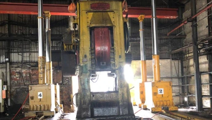 A close-up view of a heavy industrial lifting system with yellow vertical supports.